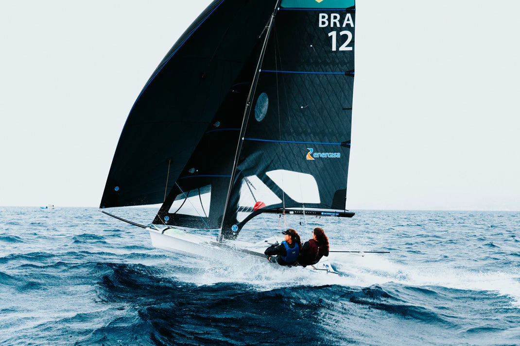 Sailboat with a large black sail on choppy waters
